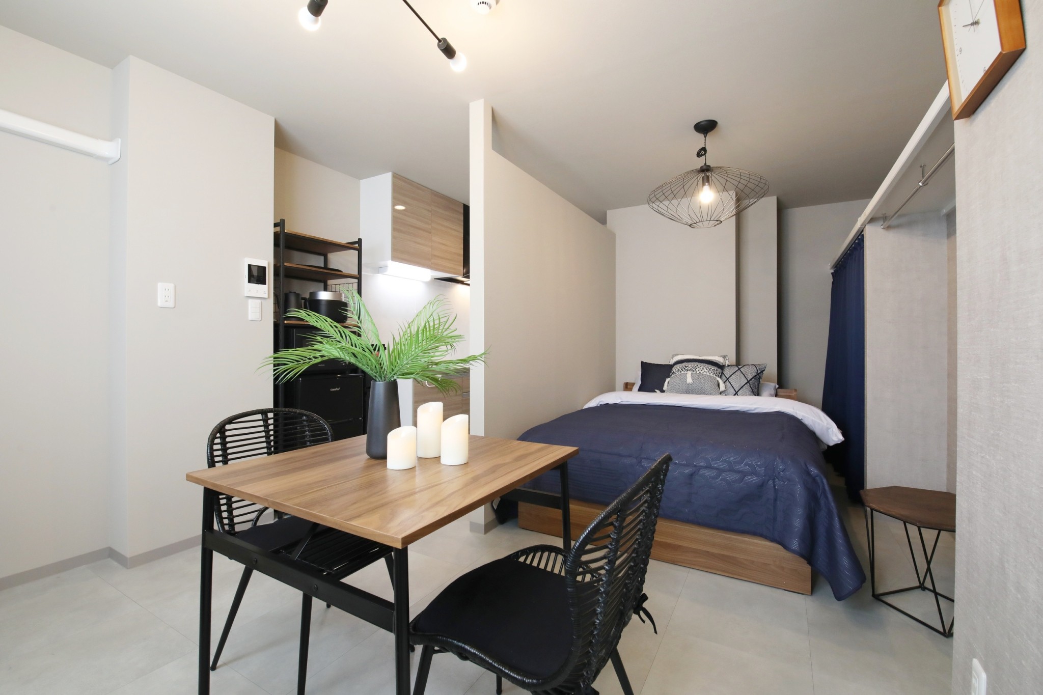 Room 101 LDK studio overview with navy blue bed and designer lighting